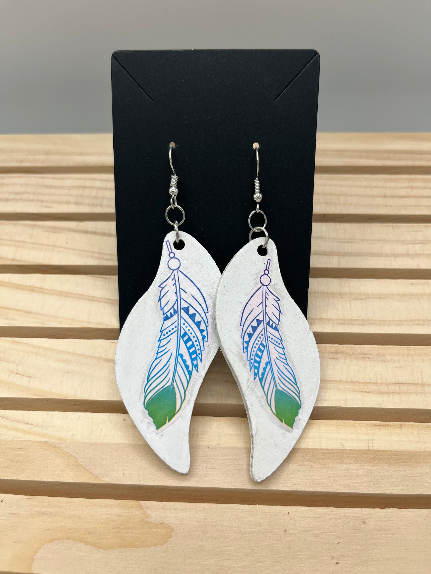 Wave shaped white earrings with feathers