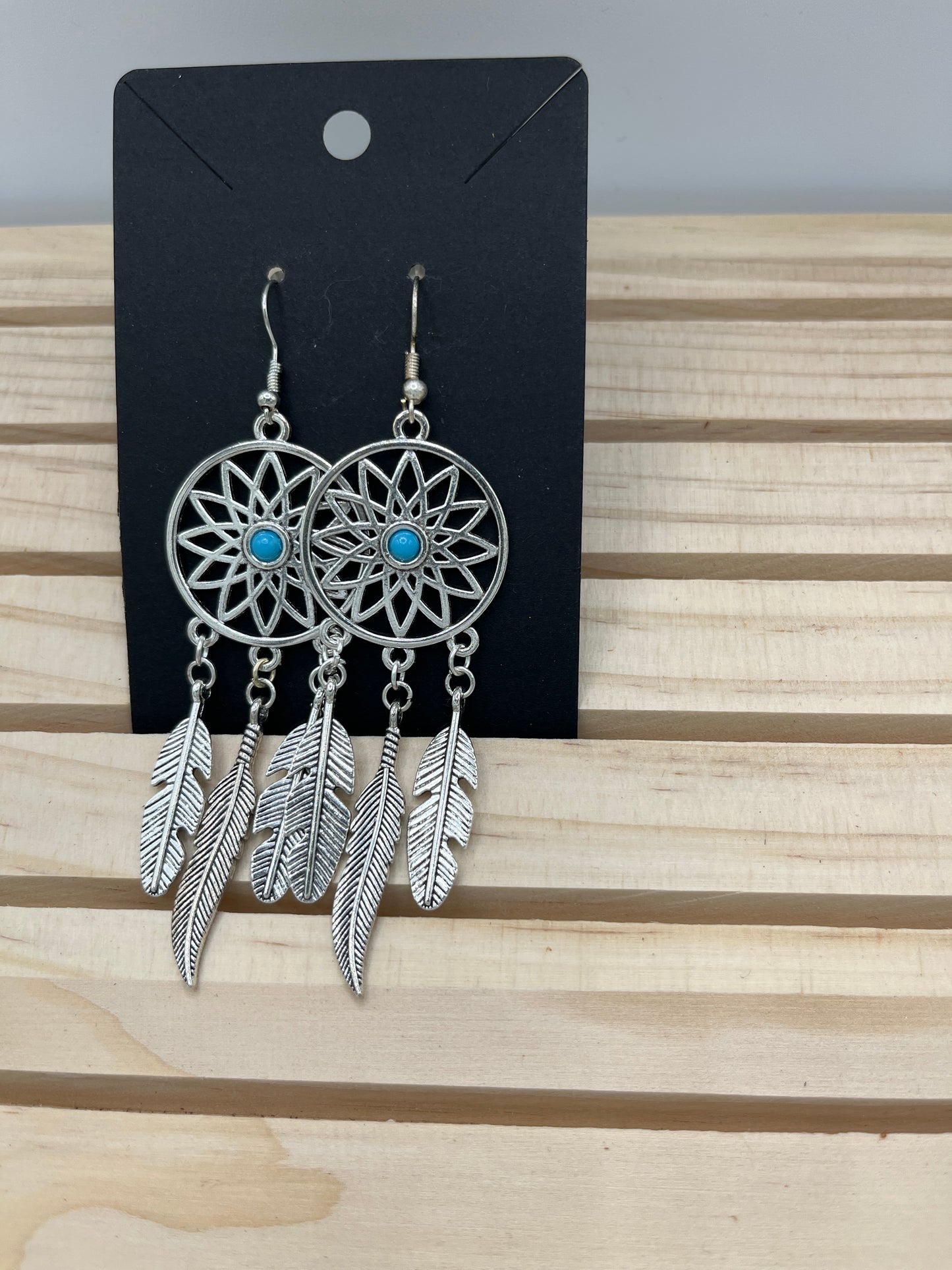 Dreamcatcher sunburst design with metal feather earrings