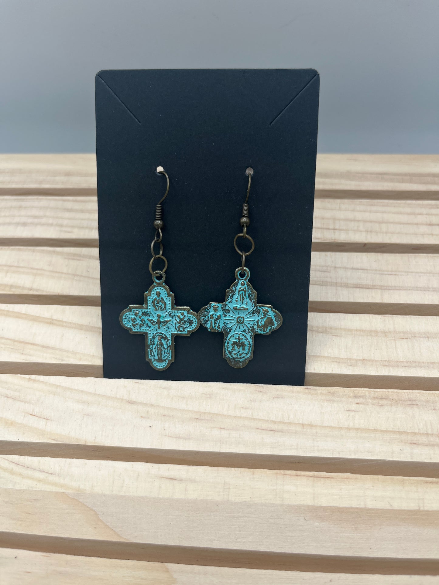 Copper oxidized cross earrings with scenes